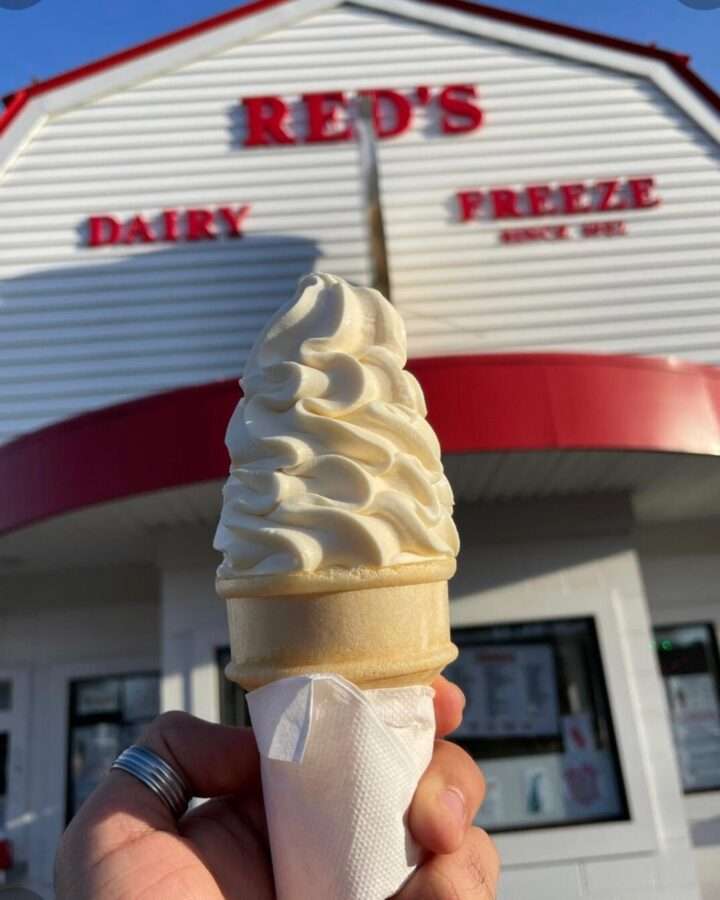 An ice cream cone held in front of Red's Dairy
