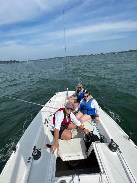 A photo of three people fishing out on the ocean during summer.